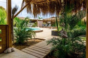 um caminho de madeira que leva a um resort com piscina em Bonaire Boutique Resort em Kralendijk