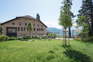 a house with a yard with trees in front of it at Apartments Windegg in Caldaro