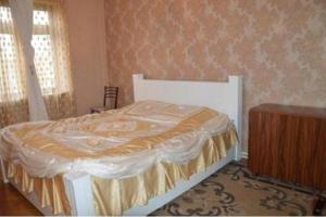 um quarto com uma cama e uma cómoda em madeira em Akaki's Apartment em Batumi
