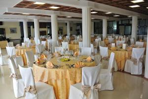 un gran salón de banquetes con mesas blancas y sillas blancas en Le Naiadi Park Hotel Sul Lago, en Bolsena