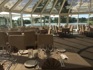 un ristorante con tavoli e sedie con bicchieri da vino di Hotel Sørup Herregaard a Ringsted