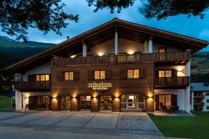 a large building with a gambrel roof at Hotel Mischun in Breil/Brigels