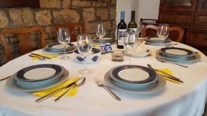 uma mesa com pratos, copos e garrafas de vinho em Mama's & Papa's house em Vrboska