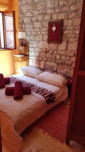 a bedroom with two beds and a stone wall at Mama's & Papa's house in Vrboska