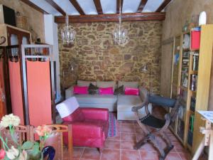 sala de estar con sofá y muebles de color rosa en Ca'ls avis, en Serra