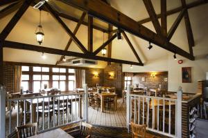 um restaurante com mesas e cadeiras num quarto em Breckland Lodge em Attleborough