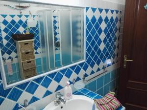 a blue tiled bathroom with a sink and a mirror at Appartamenti Sardegna in Porto San Paolo +46 photos