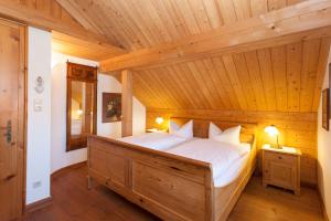 a bedroom with a large bed in a wooden ceiling at Landhaus Theresa in Bad Tölz