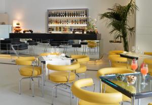 un ristorante con sedie e tavoli gialli e un bar di Palazzo Esedra a Napoli