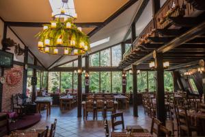 a dining room with tables and chairs and a chandelier at Cabana Schiori in Sinaia