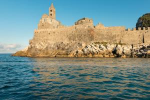 a castle on a rocky island in the water at Grand Hotel Portovenere in Portovenere
