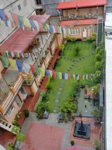 een uitzicht op een binnenplaats met een tuin met vlaggen bij Aarya Chaitya Inn in Kathmandu