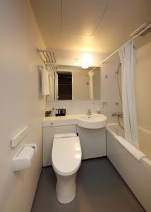 a white bathroom with a toilet and a sink at FUGASTAY Shijo Omiya in Kyoto
