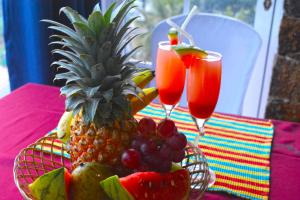 a bowl of fruit and two glasses of juice at Elegance Range Resort in Kandy