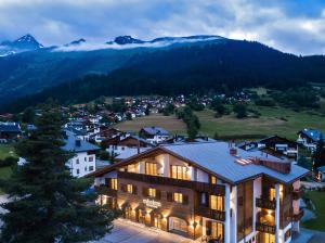 a hotel with a view of a town and mountains at Hotel Mischun in Brigels