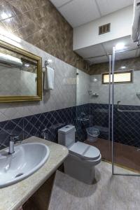 a bathroom with a toilet and a sink at Hotel Presidency-Electronic City Phase II in Bengaluru