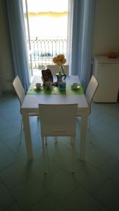 un tavolo bianco con due sedie e un tavolo con fiori di VisitPonza - Trilocale sul corso a Ponza