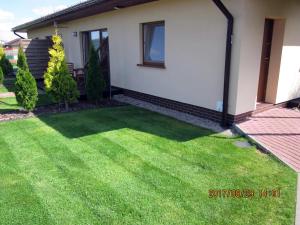 a yard with green grass in front of a house at luna in Gąski