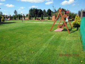 an empty park with a playground with swings at luna in Gąski +45 photos