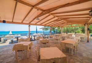 LithakiaにあるPorto Koukla Beachの海とテーブルと椅子が備わるレストラン