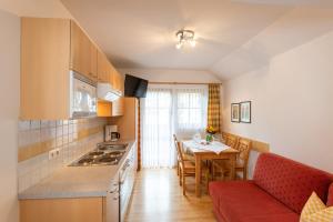 una cucina e una sala da pranzo con tavolo e divano di Ferienhof Nasnergut a Radstadt