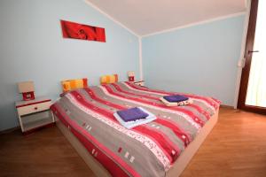 a bedroom with a bed with a colorful blanket on it at Apartments Sersic in Baška