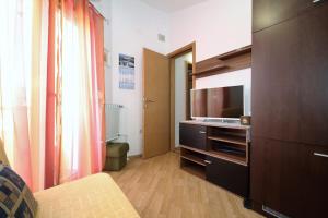 una pequeña sala de estar con TV y una habitación en Apartments Sersic, en Baška