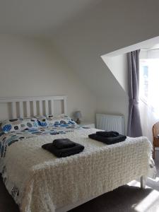 a bedroom with a bed with two towels on it at Stornoway Lido flats in Stornoway