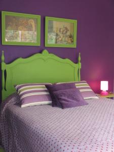 ポンタ・デルガダにあるCasa Vitorianaの紫の壁の緑のベッドが備わるベッドルーム1室が備わります。