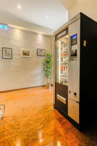 ein leeres Zimmer mit einem Kühlschrank und einer Pflanze in der Unterkunft Hotel Am Uenglinger Tor in Stendal
