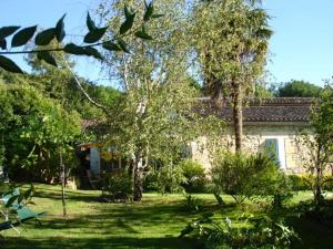 uma casa com um quintal com árvores em frente em La Petite Provence de Touron em Pujols Gironde