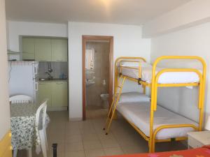 a room with two bunk beds and a kitchen at Le Zagare apartments in SantʼAlessio Siculo