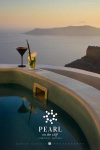 a advertisement for pearl on the cliff with a drink next to a pool at Pearl on the Cliff Hotel & Suites by Pearl Hotel Collection in Imerovigli