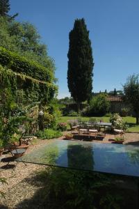 a garden with a table and chairs and a pool at I Parigi Corbinelli Residenze in Florence