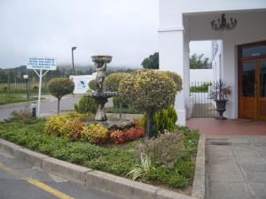 a garden in front of a building with a fountain at Mount Currie Inn in Kokstad