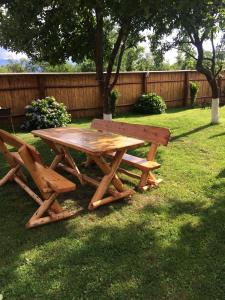 una mesa de picnic de madera y un banco en un patio en Pensiunea Bujor de Munte, en Cârţişoara