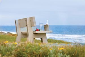 una silla blanca sentada en la playa cerca del océano en First Group Desert Rose en Hentiesbaai