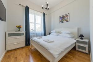 a bedroom with a large white bed and a window at Andersa Apartments in Warsaw