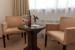 a table with two chairs and a bottle and wine glasses at Villa Diana in Rozalin