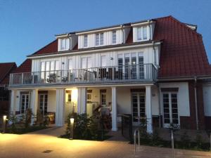 a large white house with a red roof at Friesengut4 in Langeoog