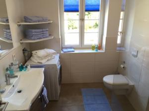 a bathroom with a sink and a toilet and a window at Friesengut4 in Langeoog