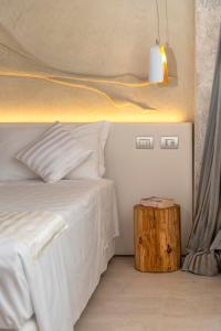 a bedroom with a white bed and a wooden table at Ca' de la Fonte - WENICE Deep Culture in Venice