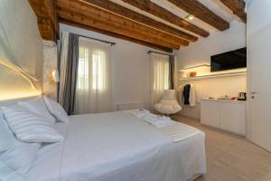a bedroom with a white bed in a room at Ca' de la Fonte - WENICE Deep Culture in Venice