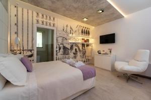 a bedroom with a large white bed and a chair at Ca' de la Fonte - WENICE Deep Culture in Venice