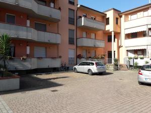 QuiesaにあるAppartamento Luminoso, tra mare e lagoの建物前の駐車場に駐車した車2台
