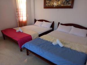 two beds sitting next to each other in a room at Khách Sạn Hoàng Thông Lý Sơn in Ly Son