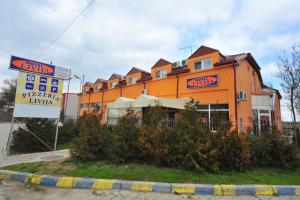 un gran edificio naranja con un cartel delante en Motel Livija, en Petrovec