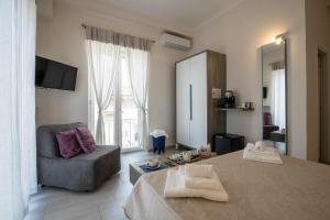 una camera con letto, sedia e specchio di Residenza Eleonora a Salerno