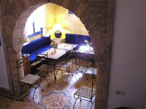 a dining room with a table and chairs and an archway at Dar Al Bahar in Essaouira