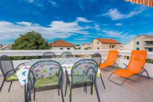 eine Terrasse mit Tisch und Stühlen auf einem Balkon in der Unterkunft Apartments Mirko&Ana in Bibinje